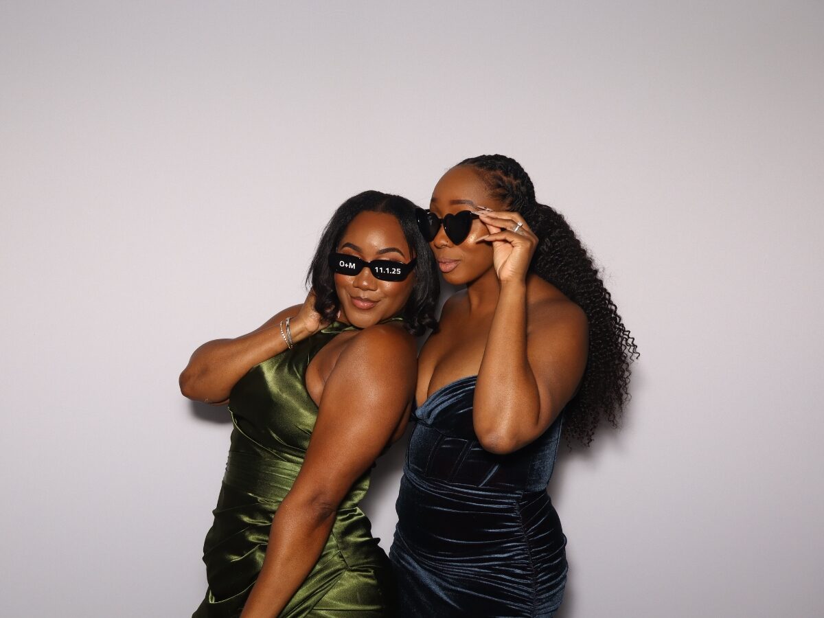 Bridesmaids posing with props in the open-air photo booth