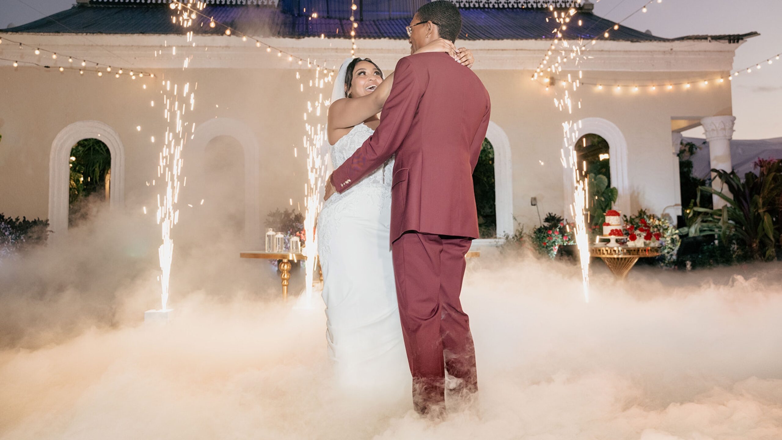 Newlyweds sharing their first dance as cold sparks and dancing on the clouds surround them