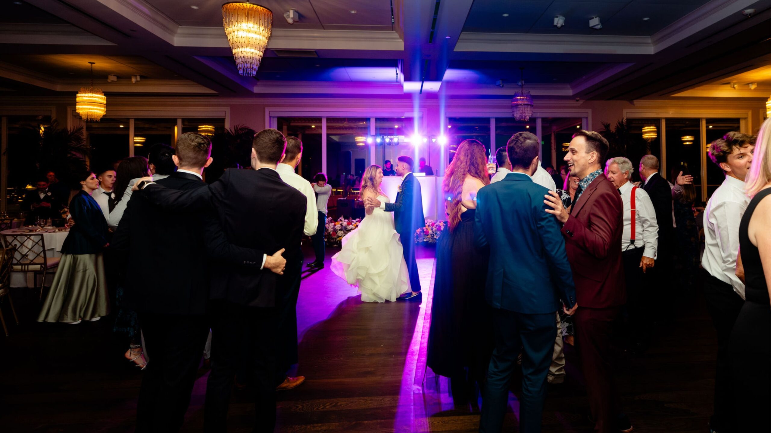 Crowded dance floor as the newlyweds dance together in the center at a South Florida wedding