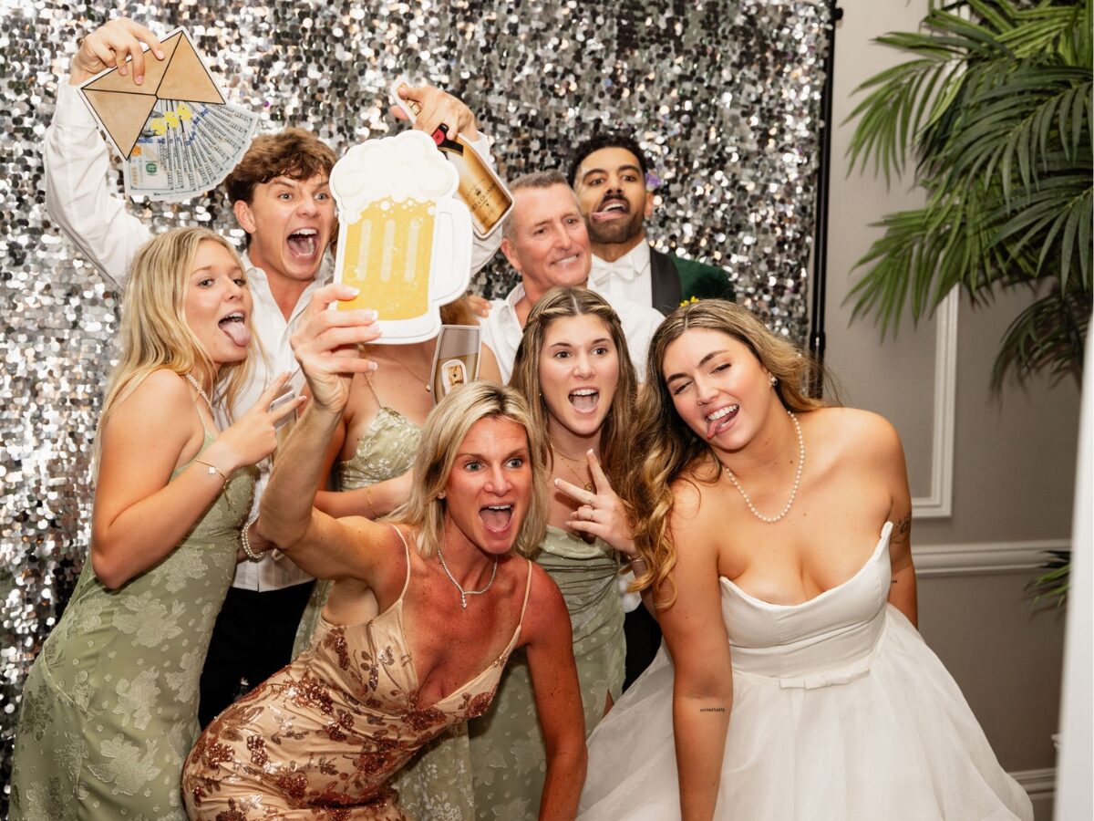 A couple enjoying their photo booth with friends at their Jupiter wedding