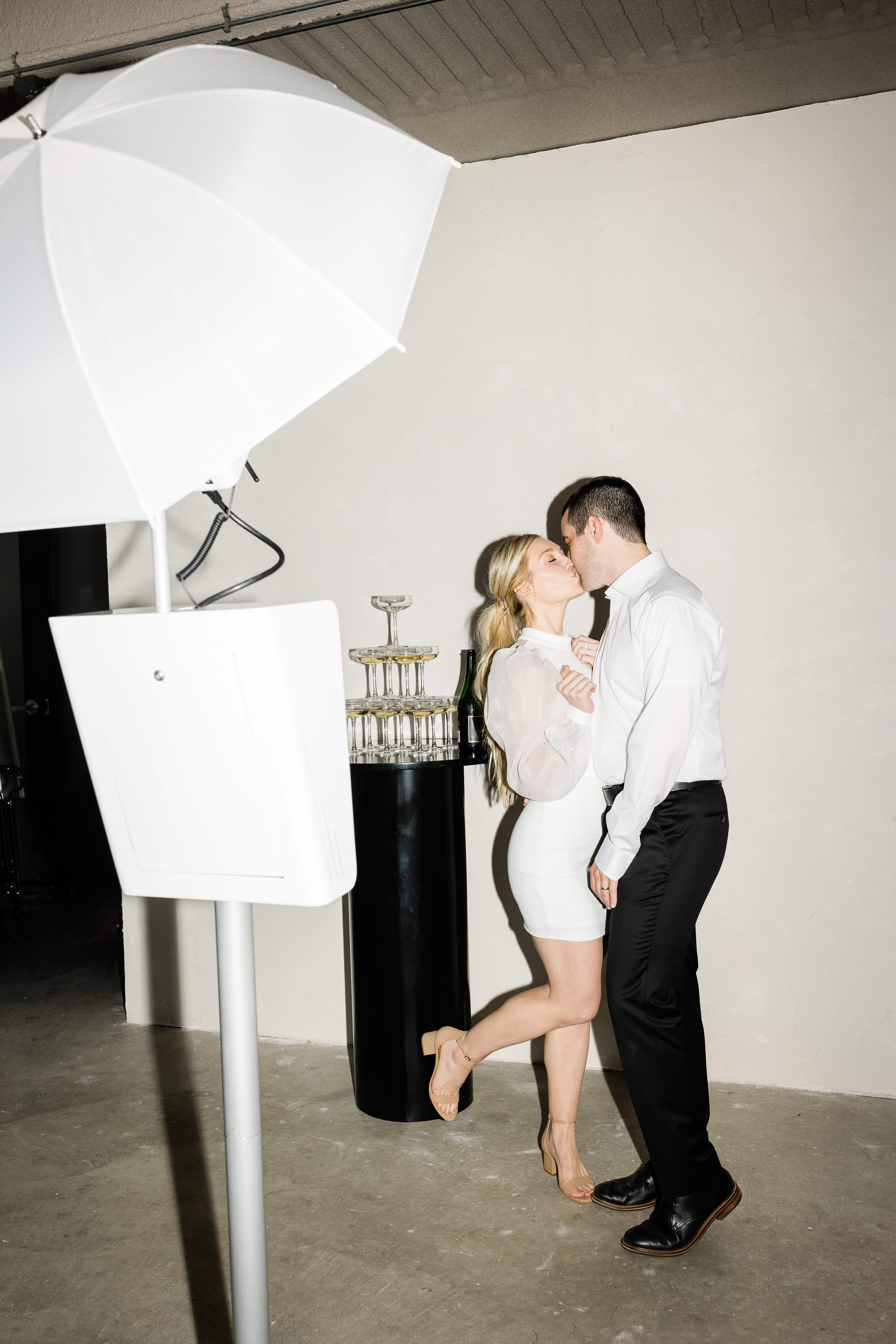 Couple posing inside an Xpress Entertainment photo booth with studio lighting